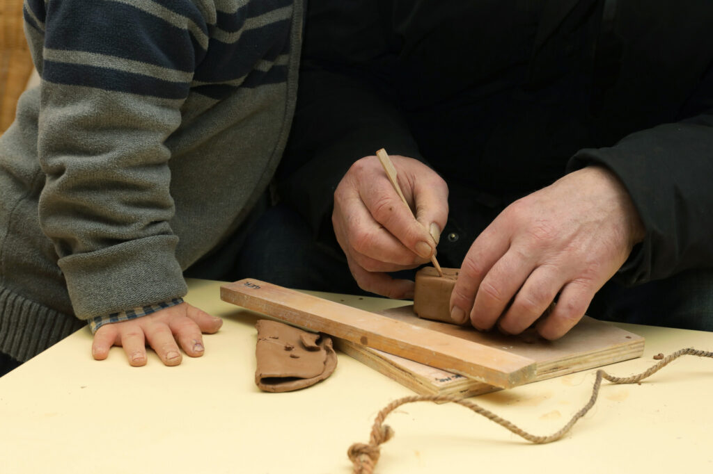 père et fils créent ensemble un objet en argile