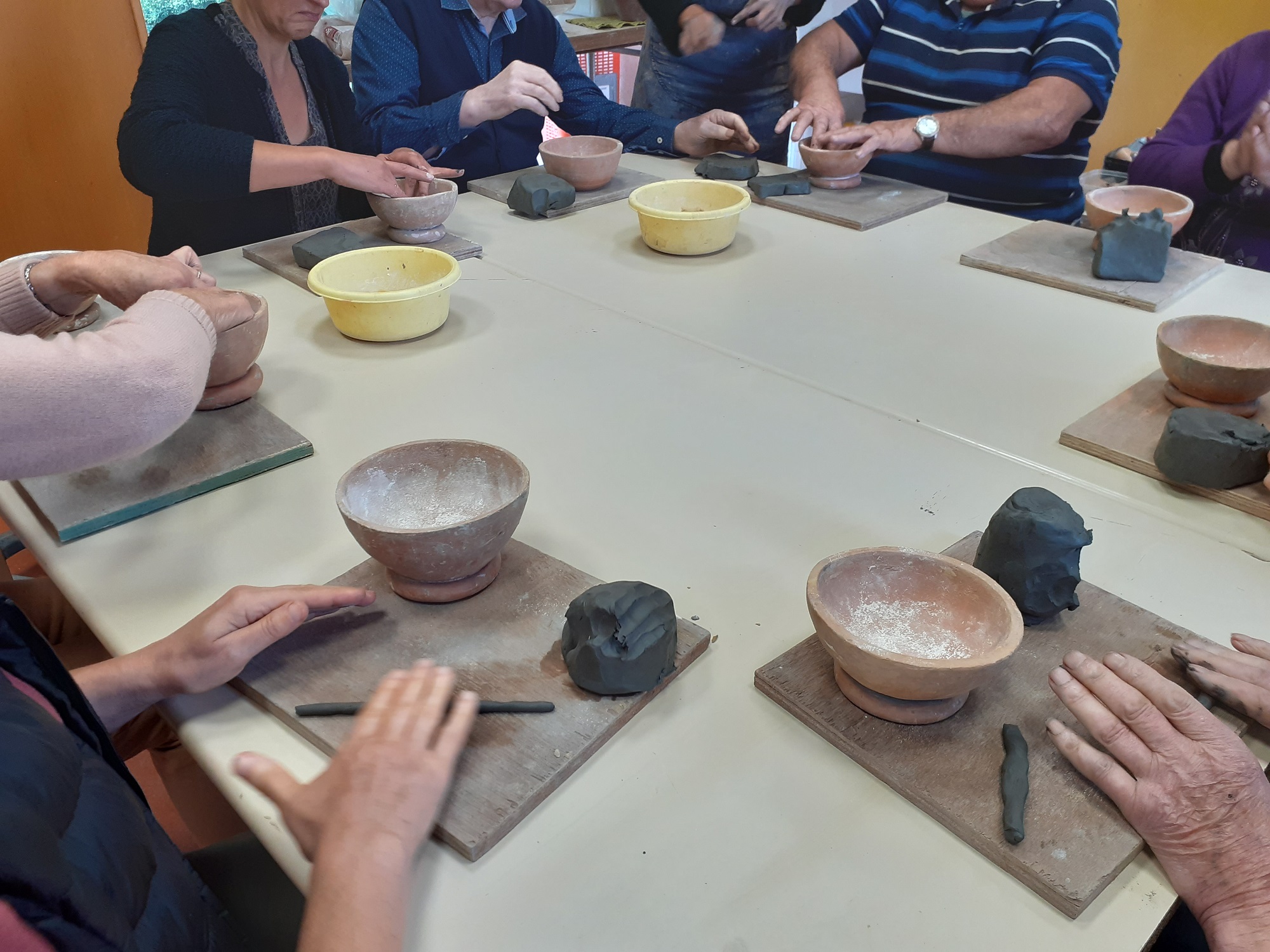 un groupe de personnes âgées participe à un atelier modelage