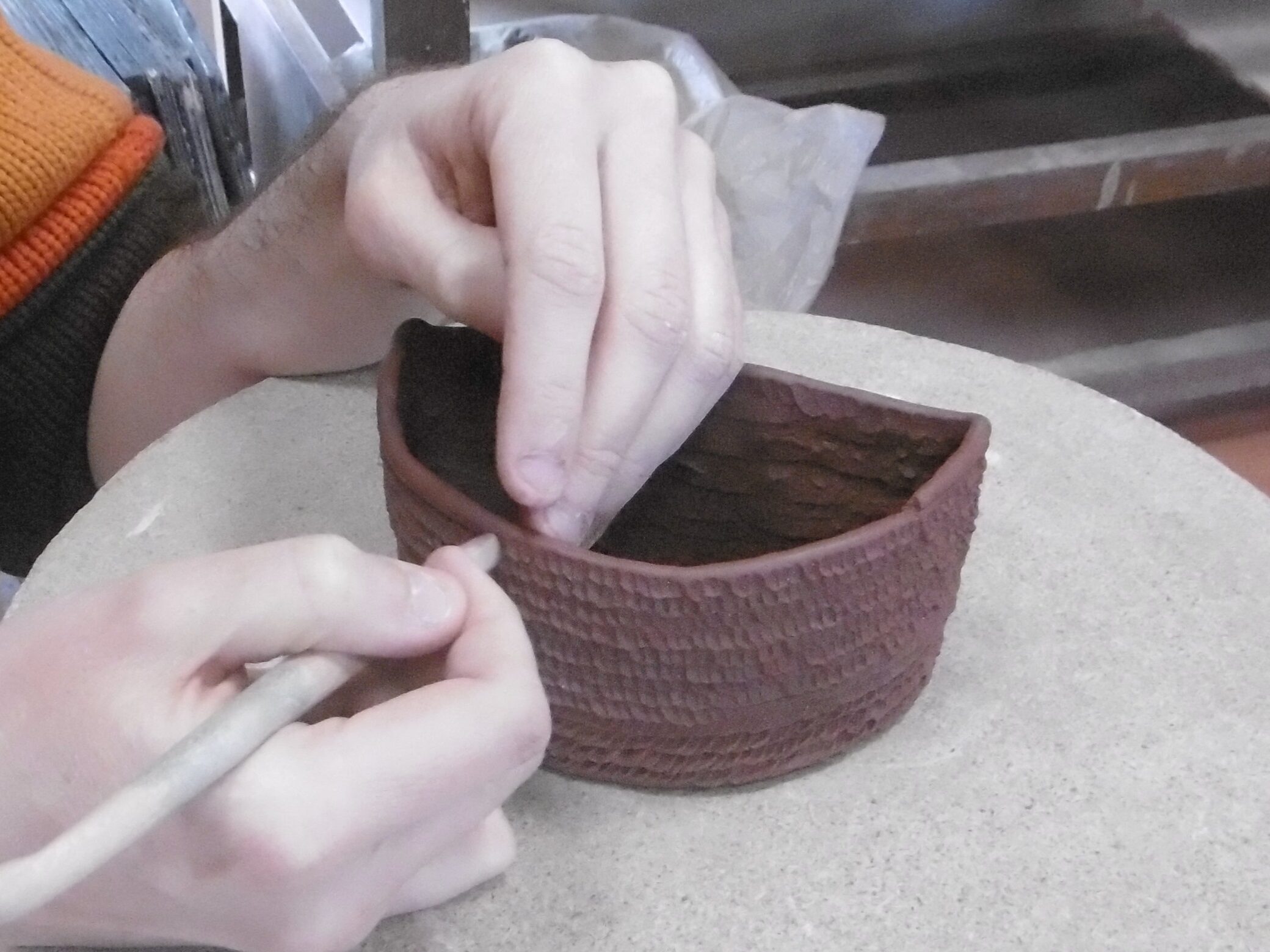 un céramiste monte un pot au colombin