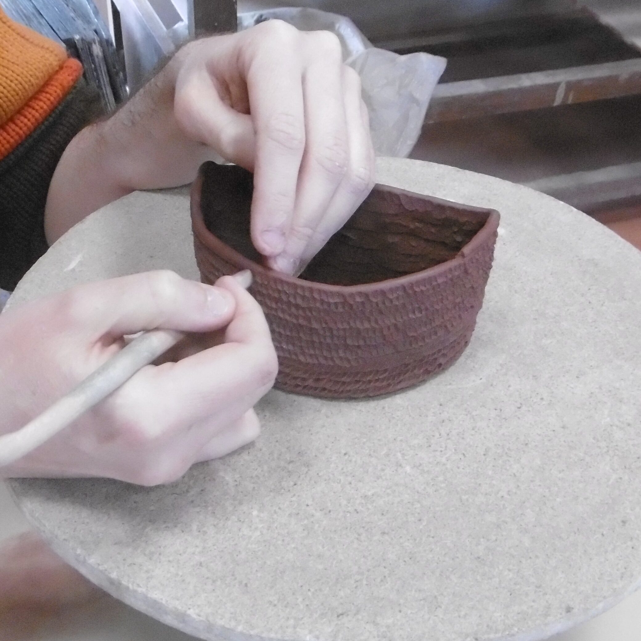 un céramiste monte un pot au colombin